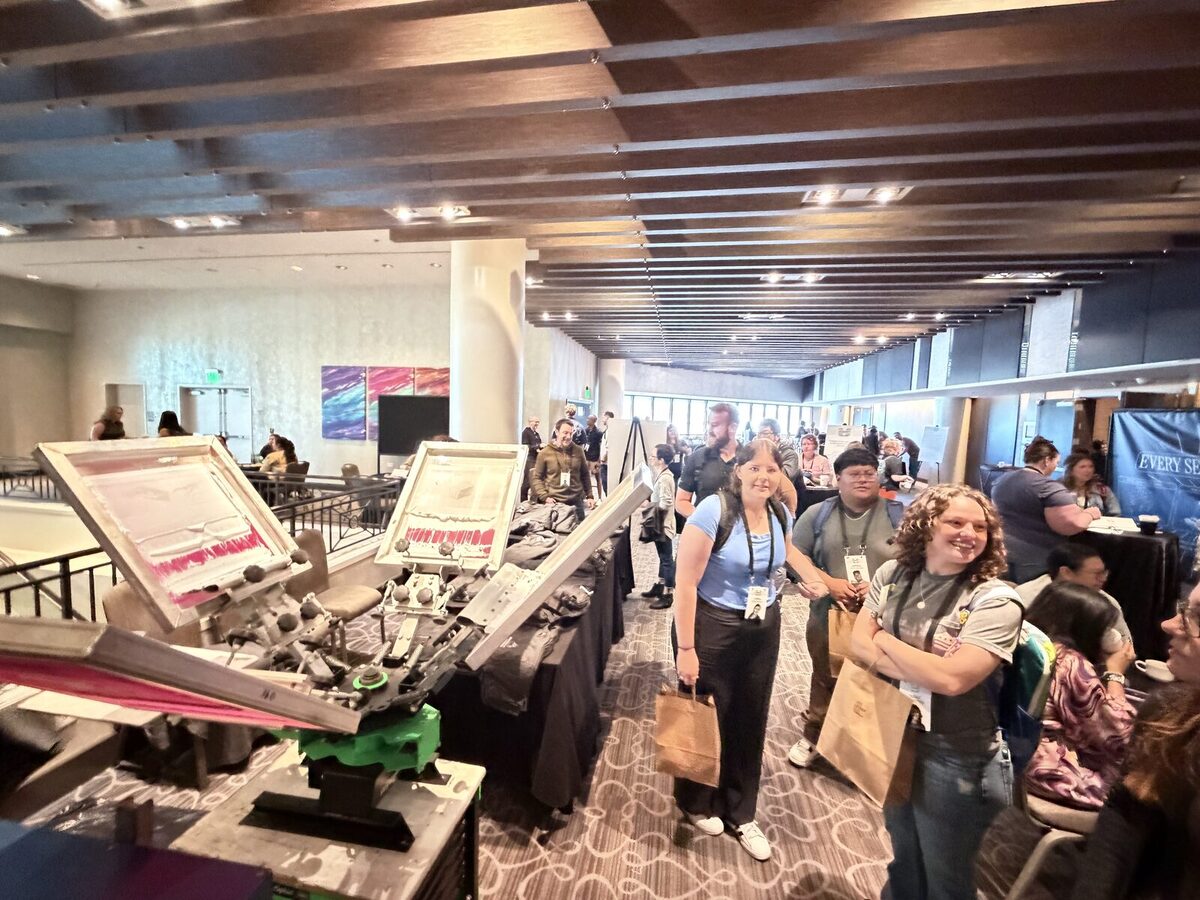 Attendees walking a large convention hall floor
