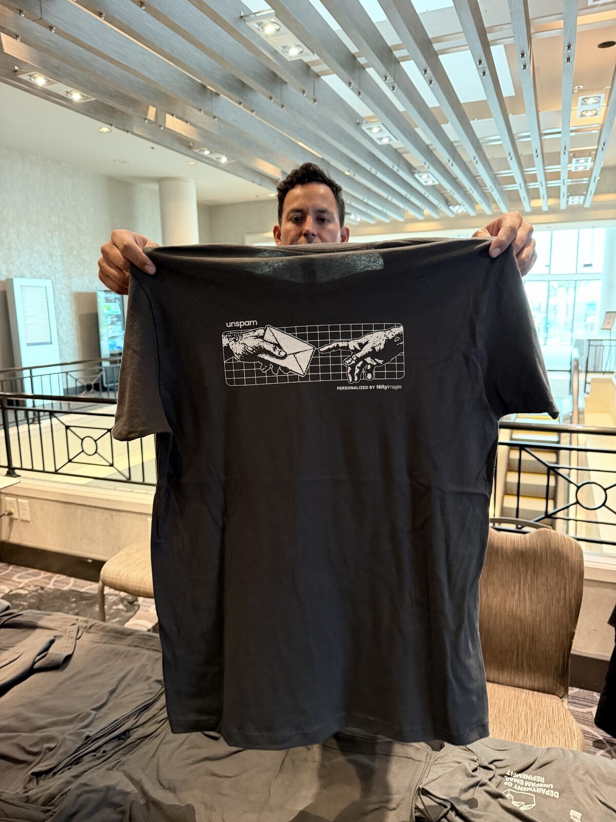 Guest holding up a freshly customized dark t-shirt at a hotel event